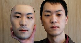 30岁的Okawara Shuhei手持自己的面具。照片通过Shuhei Okawara拍摄。