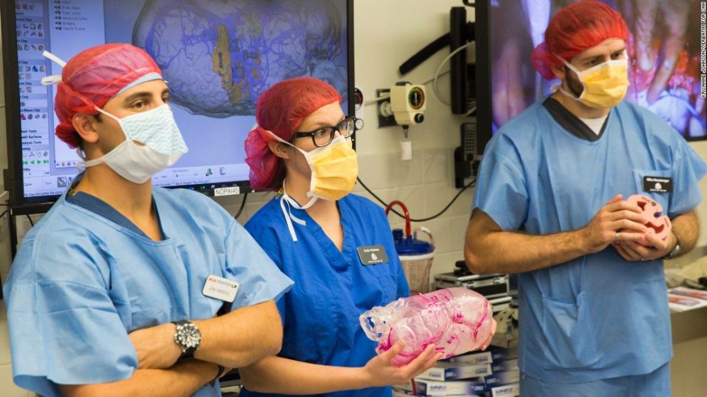 3D系统公司的Katie Weimer和Mike Rensberger拿着一个3D打印的手术模型，这个模型在MacDonald连体双胞胎的手术中使用。通过CNN的照片