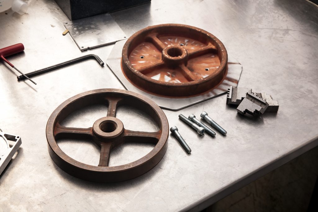 制造部分-铜滑轮制造在24分钟。图像显示了一个post机加工滑轮和一个作为印刷。通过Spee3D照片。