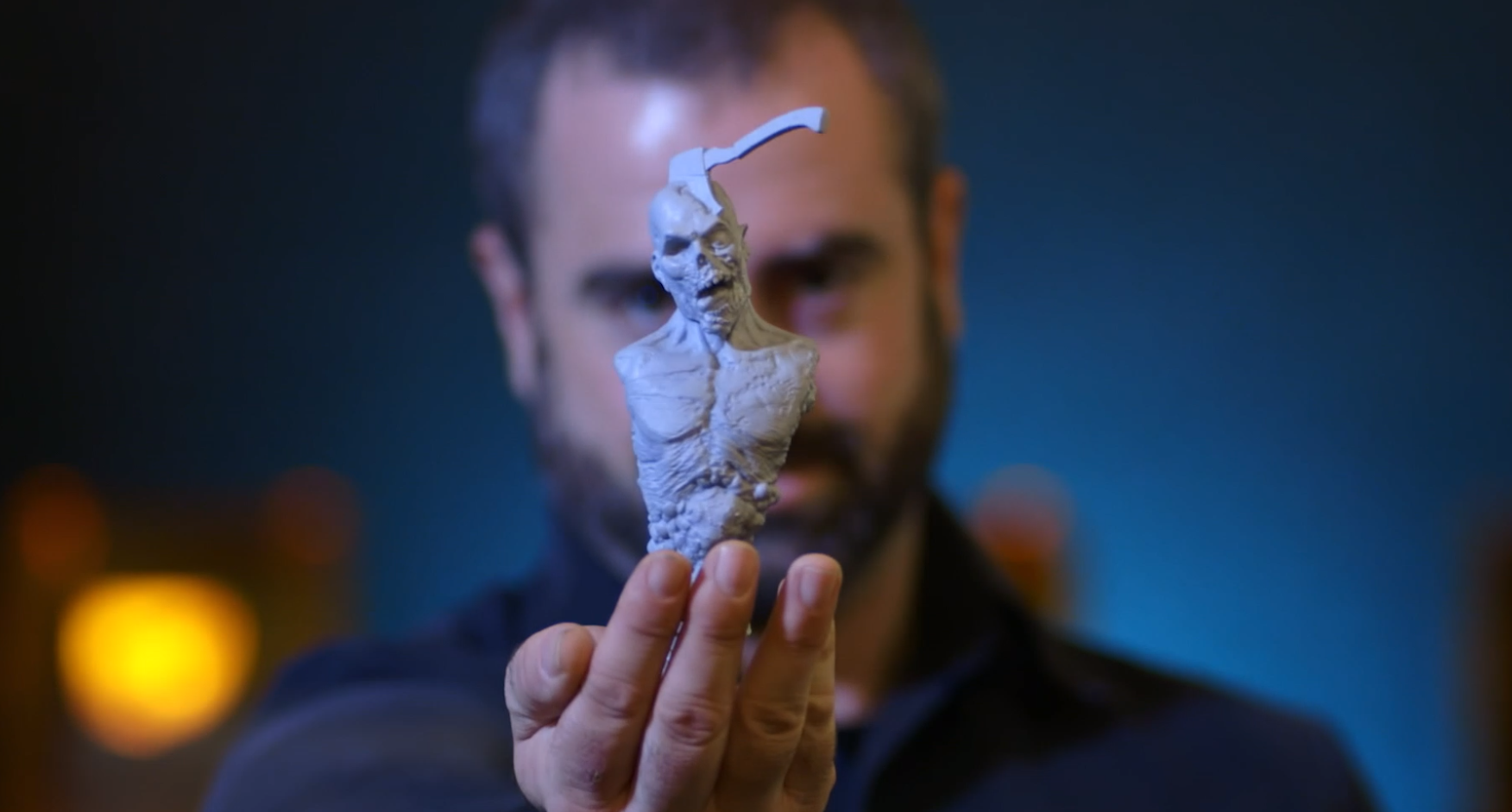 Jared Krichevsky，一个角色和生物设计师，拿着一个使用扫描-雕刻-打印工作流创建的3D打印角色。通过Formlabs照片。