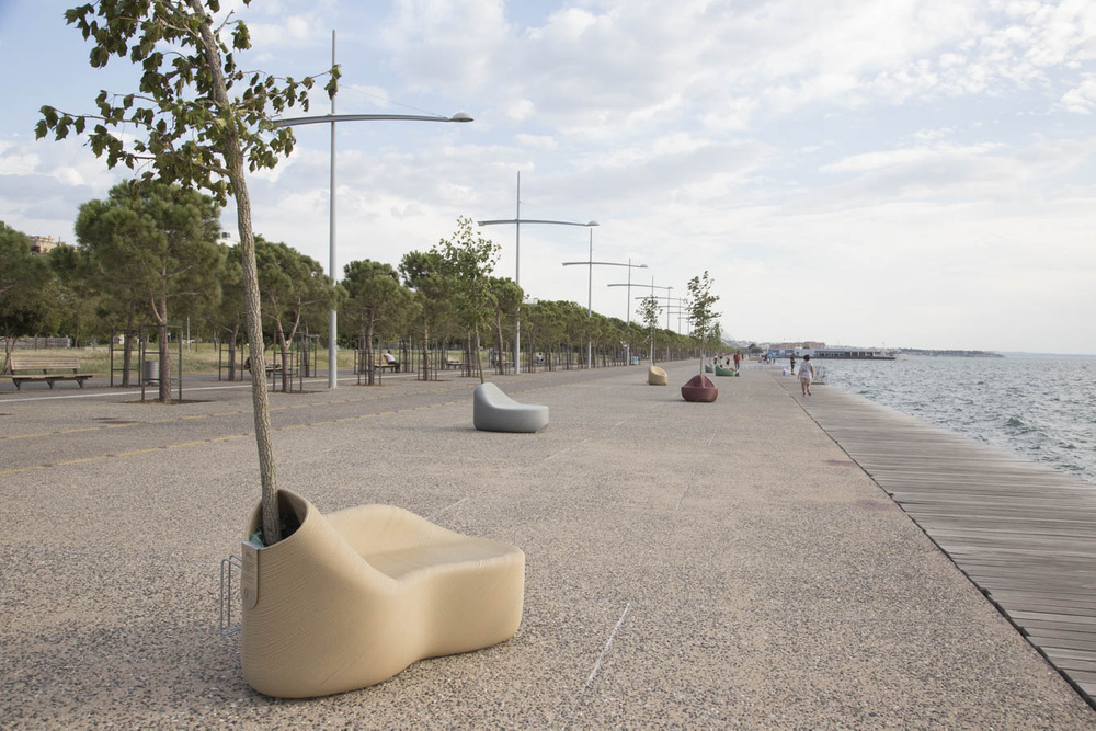 3D打印的人体工程学街道座椅，带有集成的花盆，安装在海滨。 Photo via The New Raw.