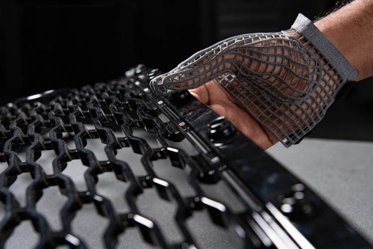 3D打印的手套用于处理生产线上的零件。通过Jaguar Land Rover的照片。