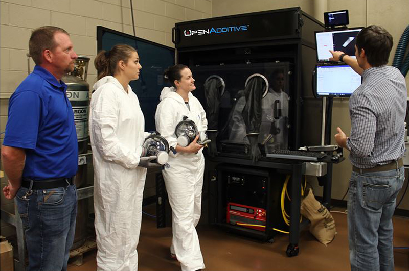 Eric Wooldridge explains to students and Curtis Cash, SCC professor of Machine Tool Technology, how the OpenAdditive PANDA System operates. Photo via SSC.