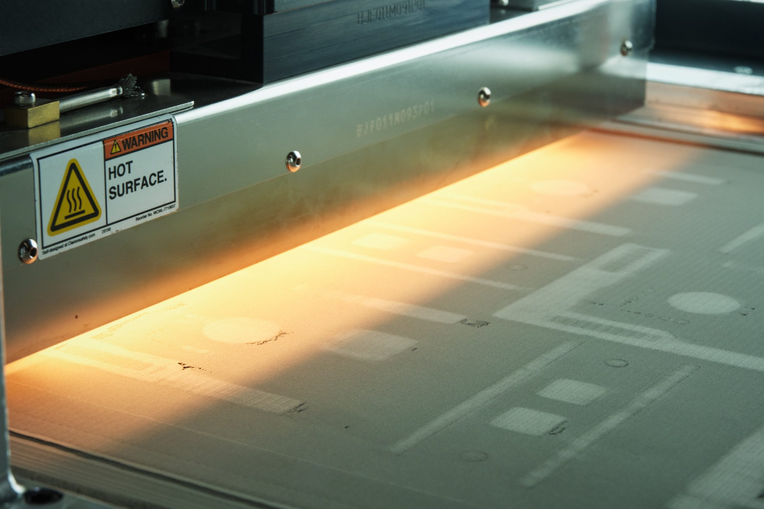 The binder jet 3D printing process on GE Additive's H2 machine. Photo via Cummins Inc.