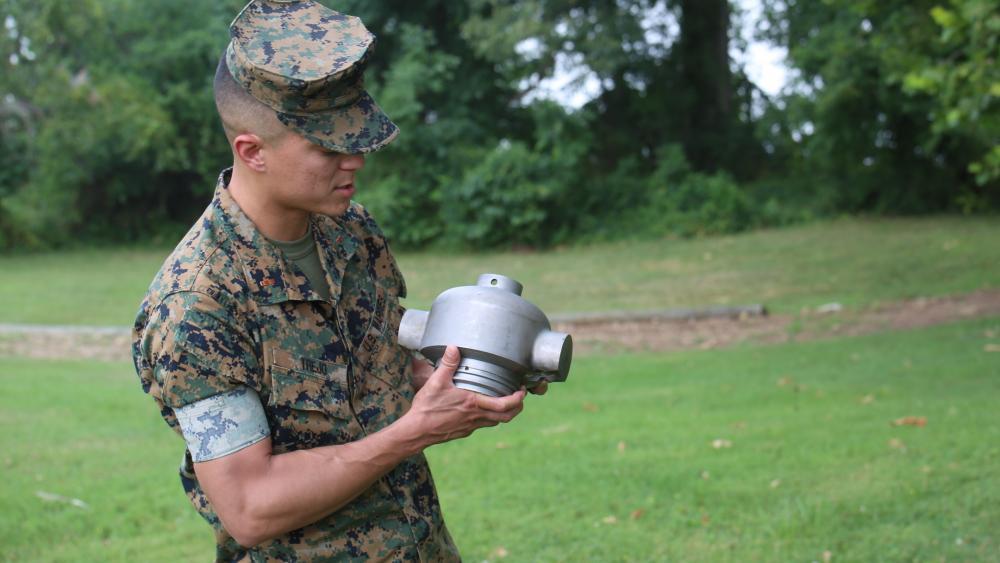 CWO2 Justin Trejo displays a 3D printed headcap for a rocket motor used to employ a M58 Mine Clearing Line Charge. Photo via Tonya Smith/US Marine Corps.