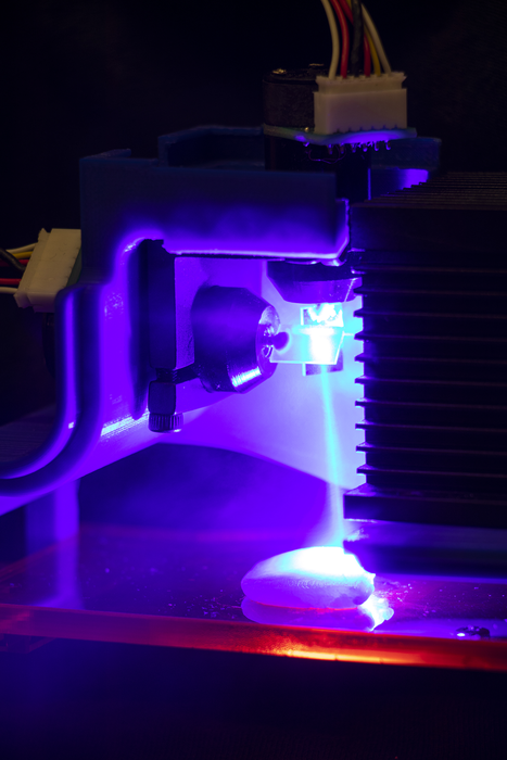 A 3D printed chicken sample being cooked by a blue laser. Photo via Jonathan Blutinger/Columbia Engineering.