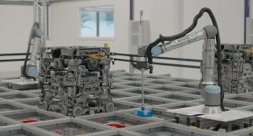 3D打印的600系列机器人与机械臂一起工作，在货车上下杂货订单。通过Ocado照片。