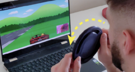 一个researcher playing a game with a 3D printed steering wheel controller.